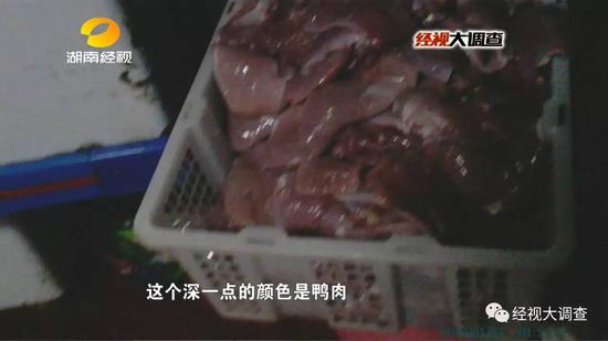 一位工人把去皮鸭大胸放入绞肉机中，把鸭肉打碎，掉到地上的鸭肉又被捡起来重新利用。